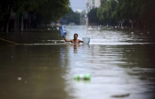 a man holds buckets as he wades through floodwater along a street in jintang county chengdu sichuan province july 11 2013 china braced on friday for the impact of typhoon soulik as the toll of dead and missing from torrential rain across a broad swathe of china climbed beyond 200 photo reuters a man holds buckets as he wades through floodwater along a street in jintang county chengdu sichuan province july 11 2013 china braced on friday for the impact of typhoon soulik as the toll of dead and missing from torrential rain across a broad swathe of china climbed beyond 200 photo reuters