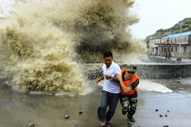 a frontier soldier helps a man move away from waves ahead of typhoon soulik in wenzhou zhejiang province july 13 2013 photo reuters a frontier soldier helps a man move away from waves ahead of typhoon soulik in wenzhou zhejiang province july 13 2013 photo reuters