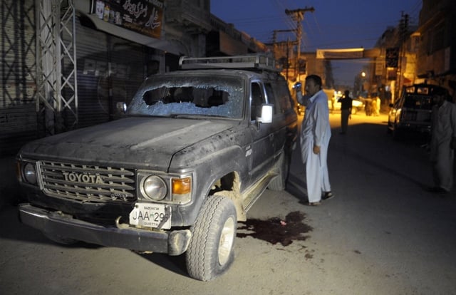 a pakistani plainclothes police officer looks at a bullet riddled vehicle after an attack by gunmen in quetta on july 15 2013 photo afp