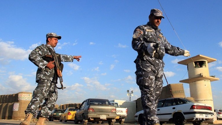 iraqi police gesture to drivers at a checkpoint to the northern iraqi city of kirkuk photo afp