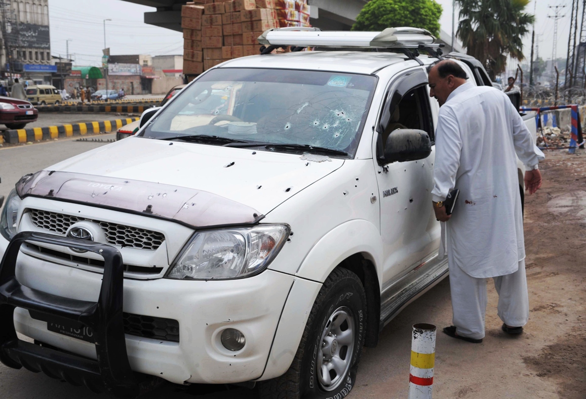 security official inspects a bullet riddled vehicle after an ambush in peshawar on july 25 2013 photo afp