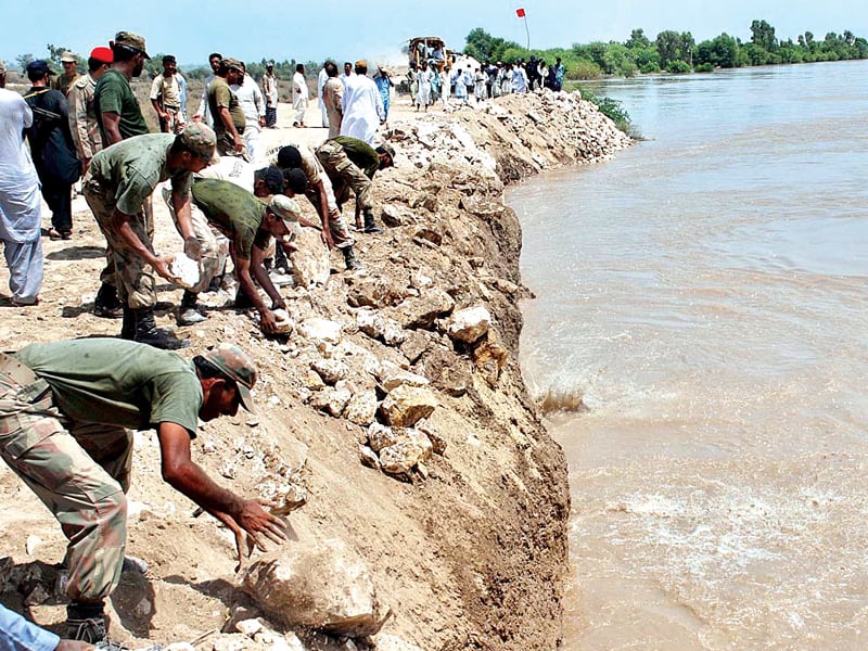 pakistan army officials dump stones to strengthen the embankment along river indus at aqil agani officials claim that encroachments and weak infrastructure along the riverbed weaken the embankments which cause floods photo file