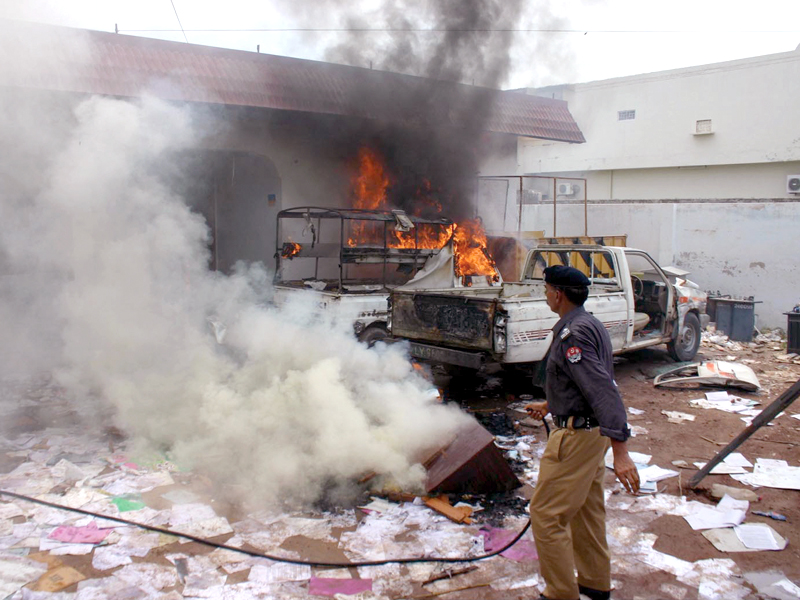 a police officer looks at the damage caused to the mepco office photo inp