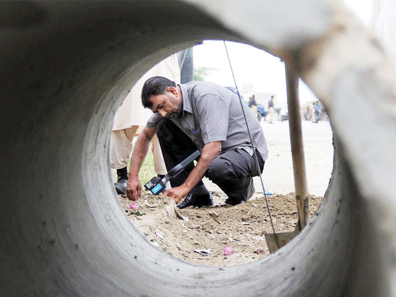 an official of the bomb disposal squad inspecting the site of the blast on manghopir which injured two rangers personnel photo online