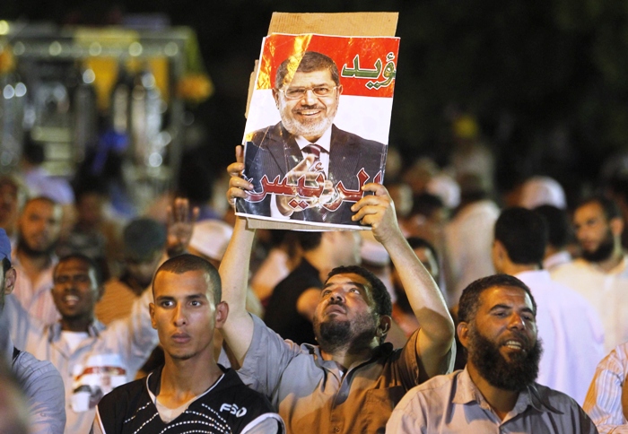 a member of the muslim brotherhood and supporter of ousted egyptian president mohamed mursi holds a poster of mursi at the raba el adwyia mosque square in cairo july 4 2013 photo reuters