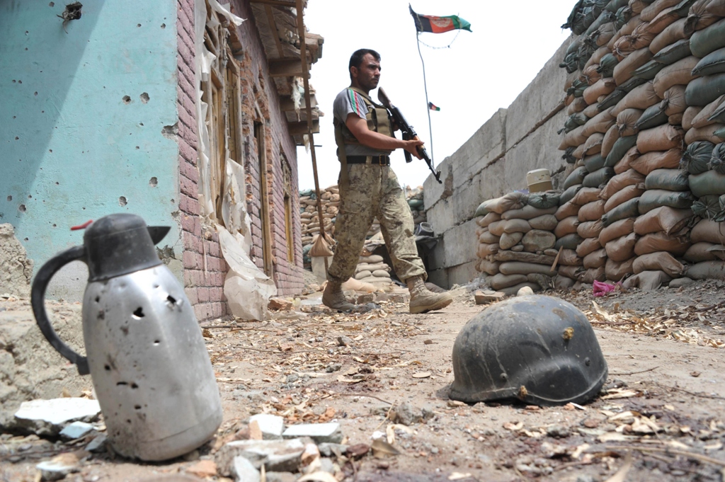 an afghan security serviceman keep watch at a damaged police post following an airstrike in bati kot district in nangarhar province on august 1 2013 photo afp