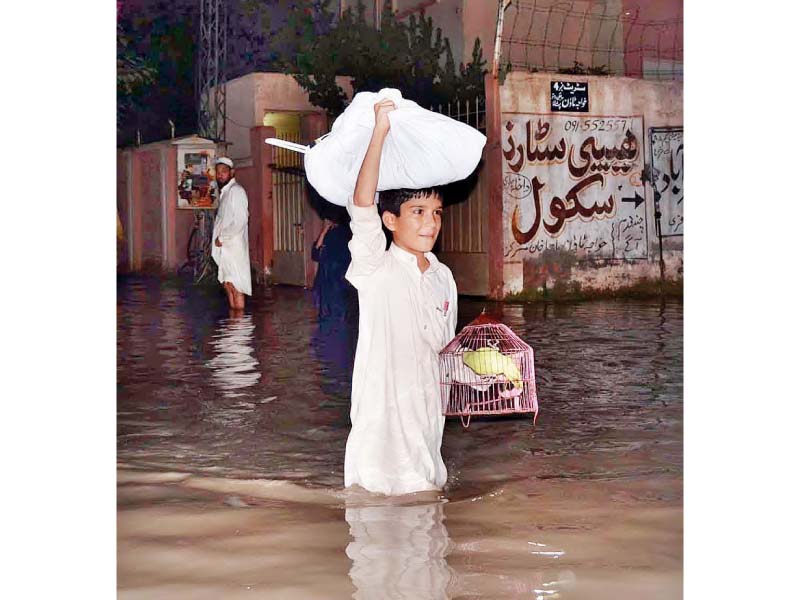 a youngster shifts his valuables to a safer place as floodwater enters budhani area near peshawar photo app