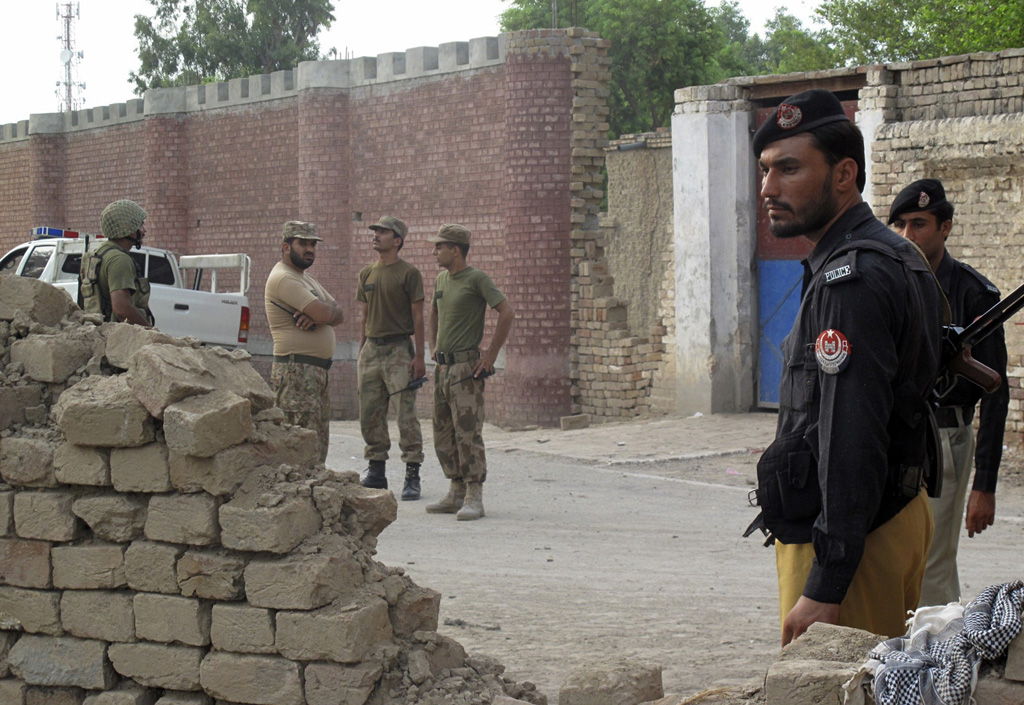 policemen r and ranger soldiers l stand outside a prison following a taliban attack in dera ismail khan july 30 2013 photo reuters