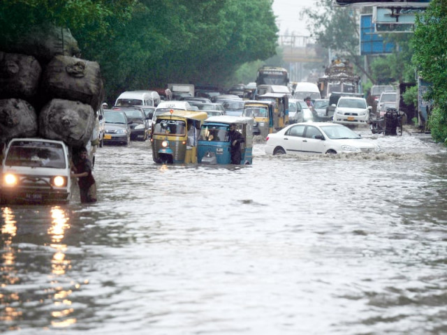 motorists drive their vehicles along a flooded road in karachi photo afp