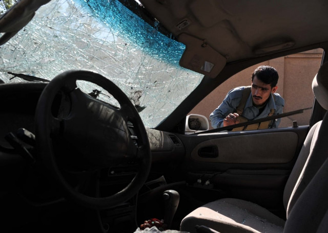 an afghan policeman inspects the wreckage of a vehicle at the site of a roadside bomb explosion in jalalabad on august 4 2013 photo afp