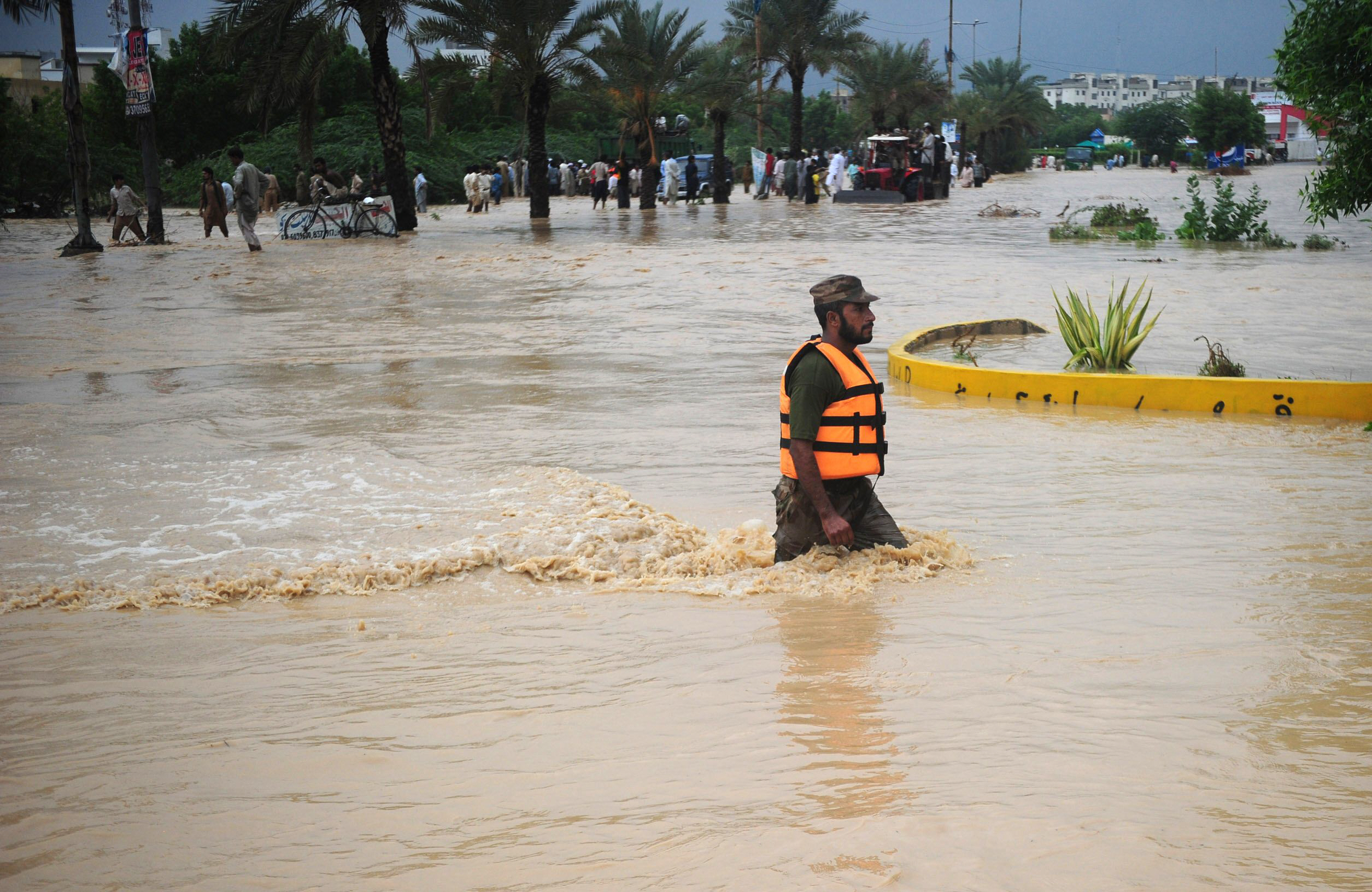 a kmc worker wades through water in an area in karachi photo afp