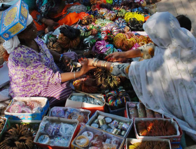 a woman selling bangles at her set up in sunday bazar photo inp a woman selling bangles at her set up in sunday bazar photo inp
