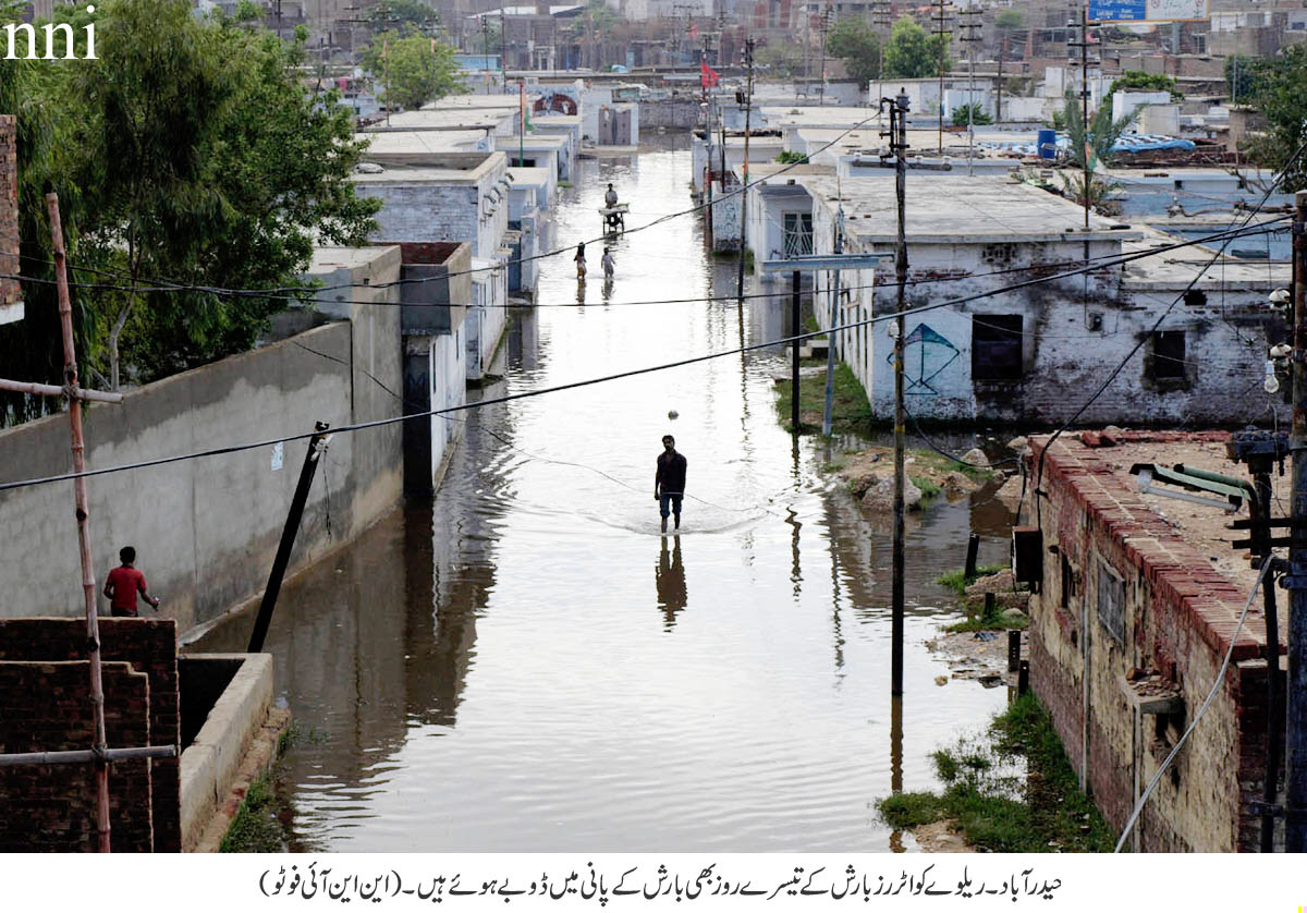 a man stands in the middle of a flooded street in hyderabad photo nni