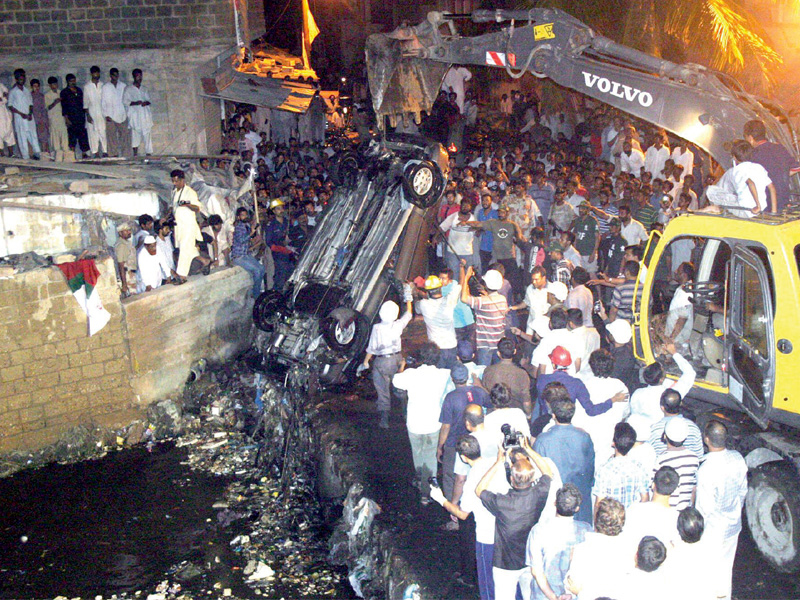 a crane is used to pull out a car from a nala that it fallen into photo express