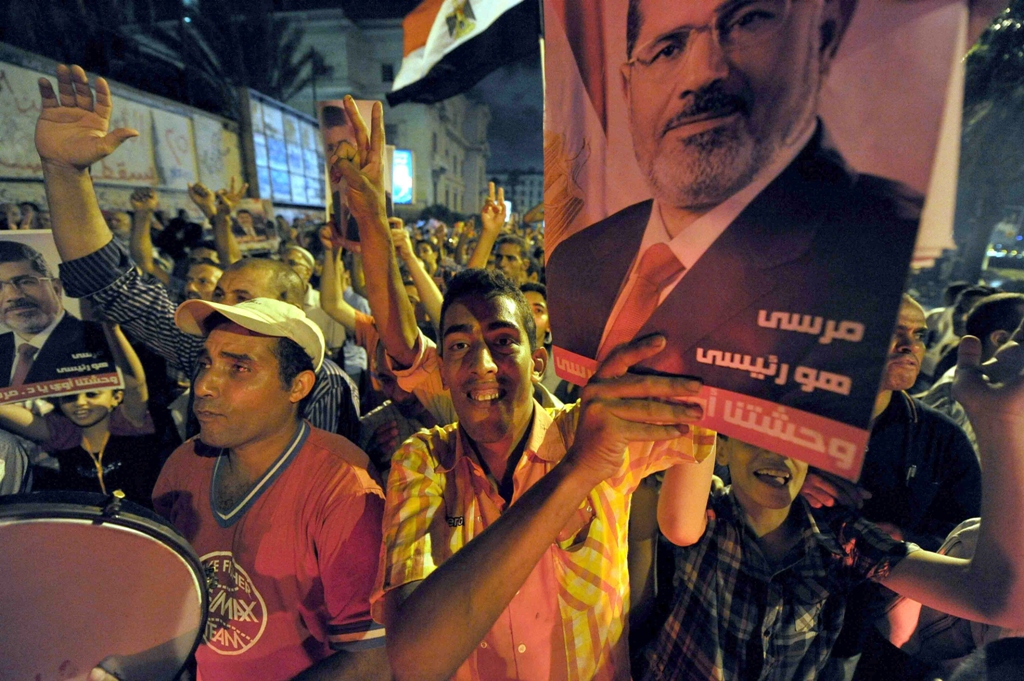 supporters of egypt 039 s deposed president mohamed morsi hold up his image during a protest in the mediterranean city of alexandria late on august 5 2013 photo afp