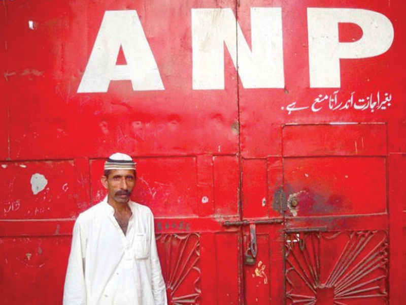 a supporter of the awami national party stands outside the closed doors of the party s office in sohrab goth karachi the party decided to keep their offices shut following a string of attacks on its offices during the elections photo file