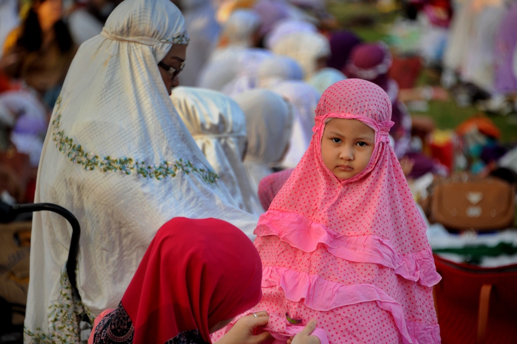 a young girl is pictured as indonesian muslims take part in special morning prayers near the bajrah sandhi monument in denpasar on indonesia 039 s island of bali on august 8 2013 photo afp