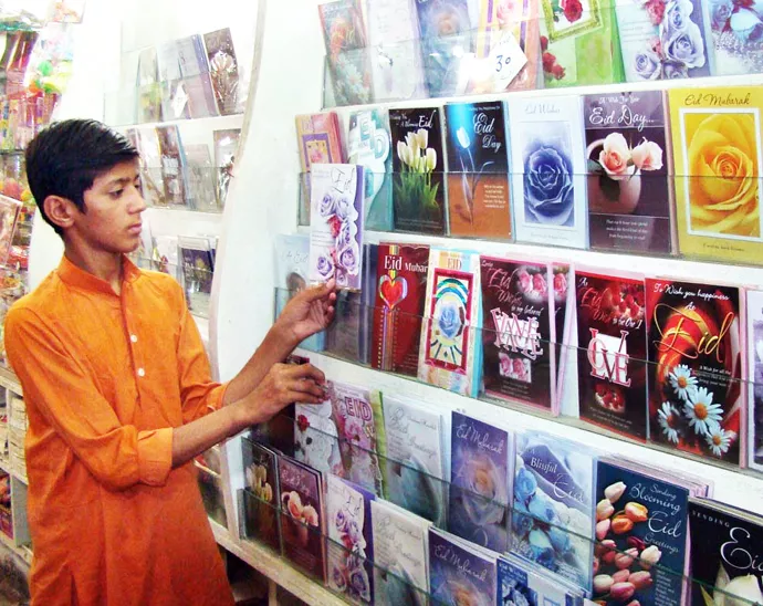 a young man selecting eid cards in pakistan photo app file a young man selecting eid cards in pakistan photo app file