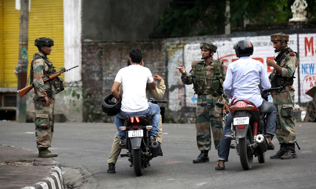 indian army soldiers speak with motorcyclists during a curfew in jammu on august 11 2013 photo afp