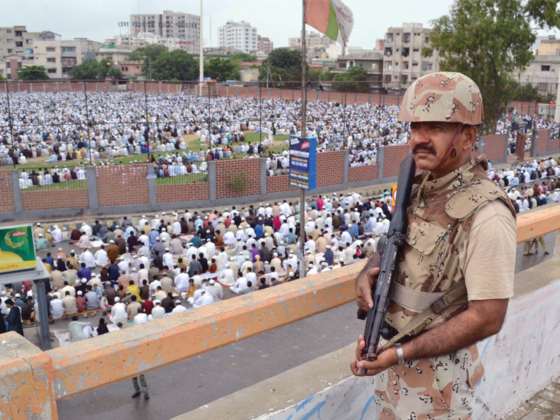 a rangers official stands guard at the eid prayers being held at the eidgah ground in nazimabad over the three days at least 22 people were killed in the city police officials said that the security in the city was heightened to pre empt terrorist activities photo rashid ajmeri express