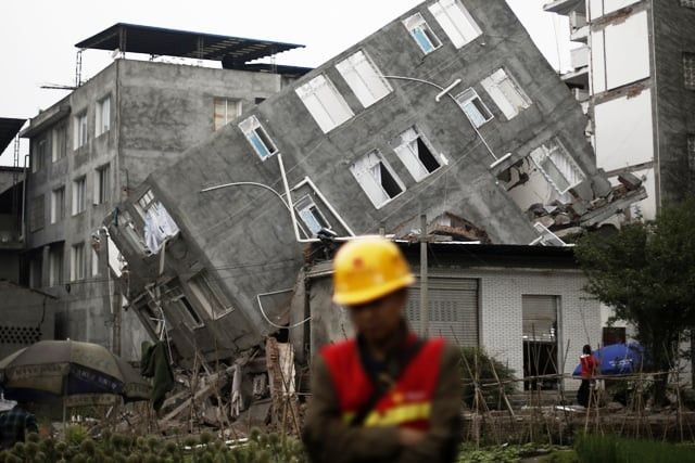 a rescuer walks in front of a damaged building after the earthquake in april in lingguan town of baoxing county sichuan province photo reuters a rescuer walks in front of a damaged building after the earthquake in april in lingguan town of baoxing county sichuan province photo reuters