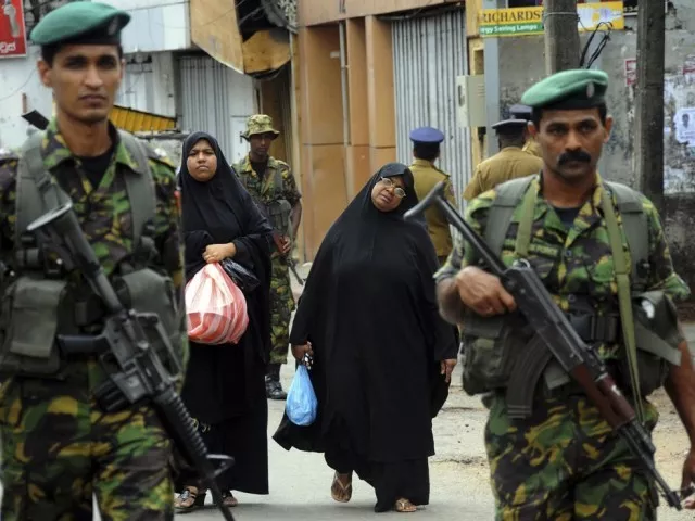 two muslim women walk behind patrolling special task force commandos outside the mosque that was vandalised photo reuters two muslim women walk behind patrolling special task force commandos outside the mosque that was vandalised photo reuters