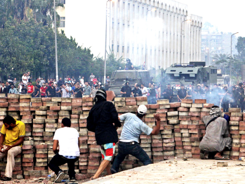 mursi supporters throw stones at police from behind a barricade during clashes in cairo photo reuters