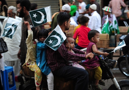 pakistani children carry national flags as they ride on a motorcycle ahead of the country 039 s independence day in karachi on august 12 2013 photo afp