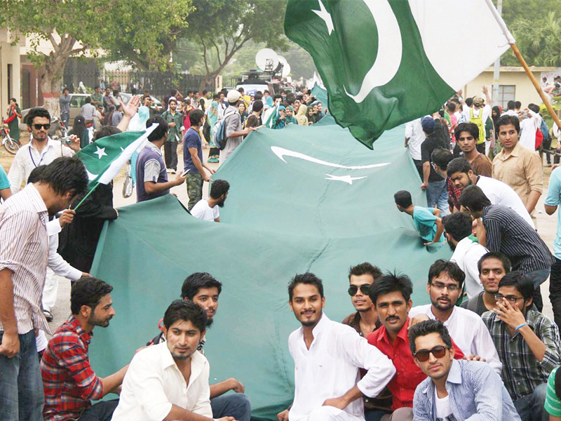 students of karachi university carry a 200 feet long national flag during a rally on the eve of the 66th independence day of pakistan photo online