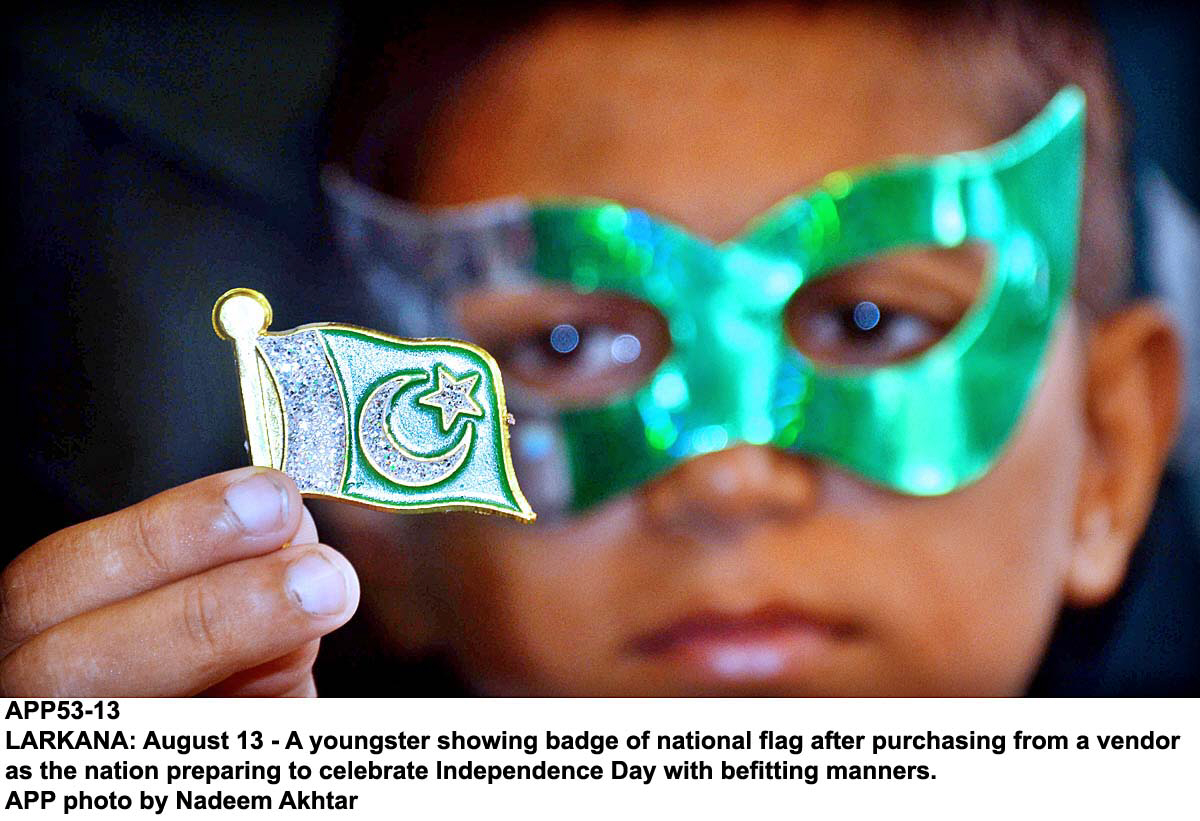 a youngster shows a badge in the shape of a pakistani flag ahead of the independence day celebrations photo app