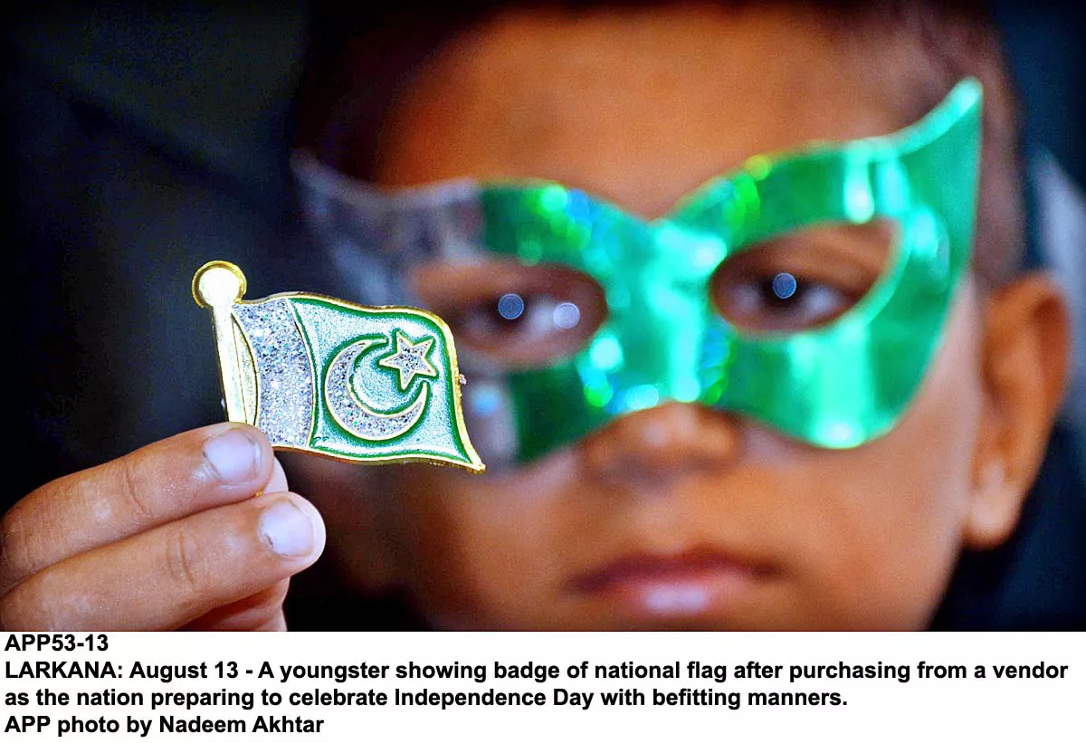 a youngster shows a badge in the shape of a pakistani flag ahead of the independence day celebrations photo app a youngster shows a badge in the shape of a pakistani flag ahead of the independence day celebrations photo app