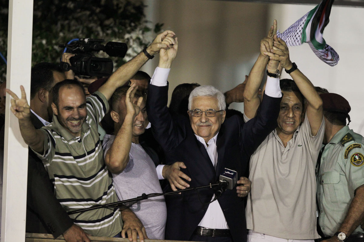 palestinian president mahmoud abbas holds hands with released palestinian prisoners at his headquarters in the west bank city of ramallah august 14 2013 photo afp