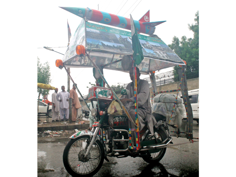 lala pakistani with his decorated bike carrying pictures of martyred army personnel and a model of ghauri missile photo athar khan express