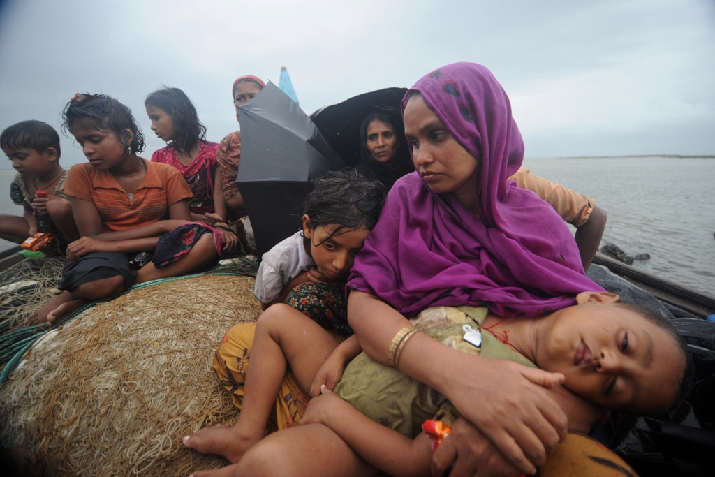 this file picture taken on june 13 2012 shows rohingya muslims trying to cross the naf river into bangladesh to escape sectarian violence in myanmar look on from an intercepted boat in teknaf photo afp