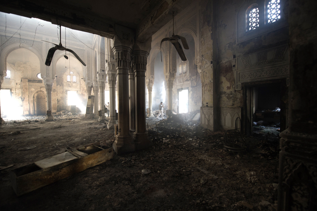 egyptian men walk through debris and rubble inside the burnt down mosque of rabaa al adawiya on august 15 2013 in cairo photo afp