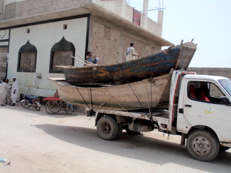 muhammad sukhio from bunder road sukkur is seen building a boat and says he has been doing so just like his forefathers whereas a transporter loads two boats for client delivery charging rs3 000 to rs4 000 per day photo sarfaraz memon express