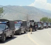 a police officer stands guard beside a convoy of vehicles for police patrol in muzaffarabad photo reuters