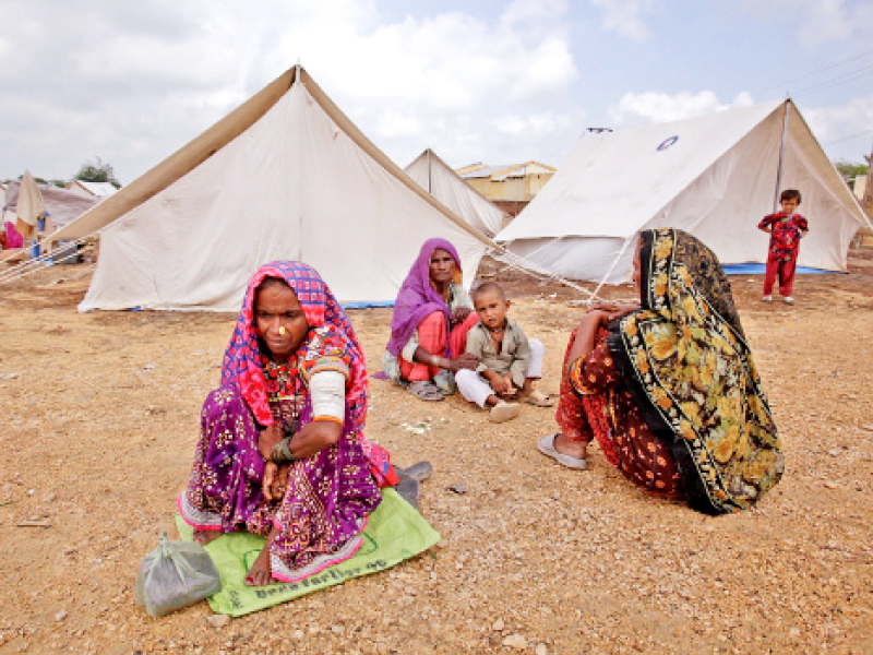 this file photo shows women who were displaced by the floods in 2011 sitting outside their tents while taking refuge along a road in golarchi badin according to the report by the pakistan relief foundation due to the damage caused by the previous three floods the rains this year could prove to be more disastrous for sindh