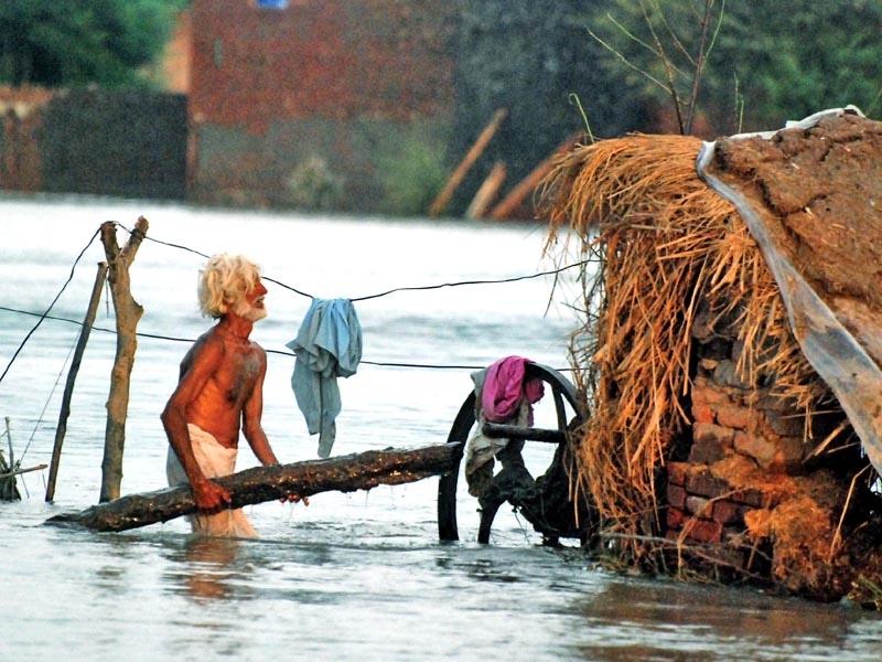 a man stands in front of his house submerged in floodwater in sargodha photo muhammad farooq express