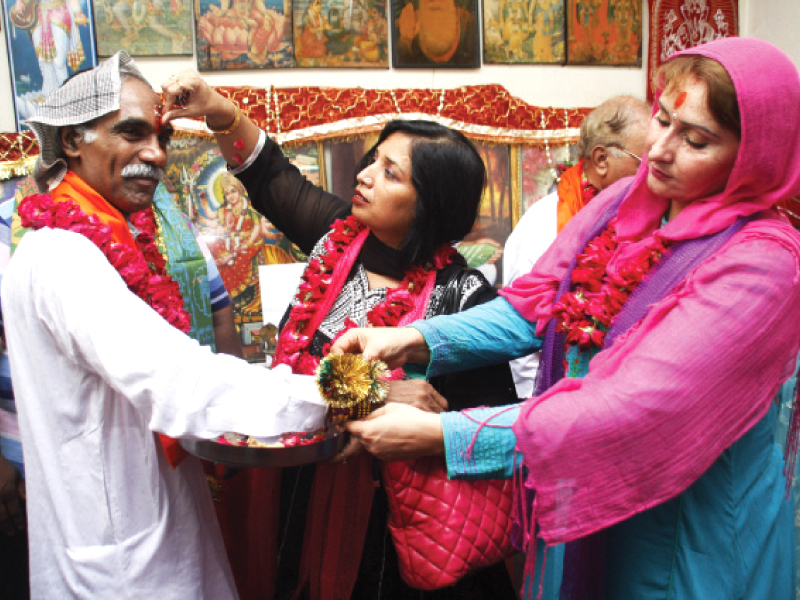 a sister ties a rakhi on her brother s wrist at the balmiki temple in nila gumbad photo abid nawaz express