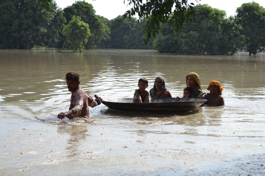 pakistani villagers wade through floodwaters on the outskirts of multan on august 21 2013 photo afp