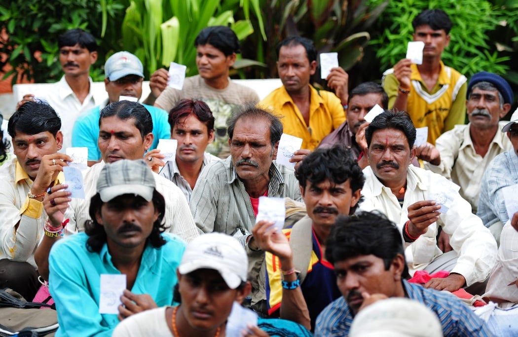 indian fishermen hold up documents as they wait for transport after their release from prison in karachi on august 23 2013 photo afp