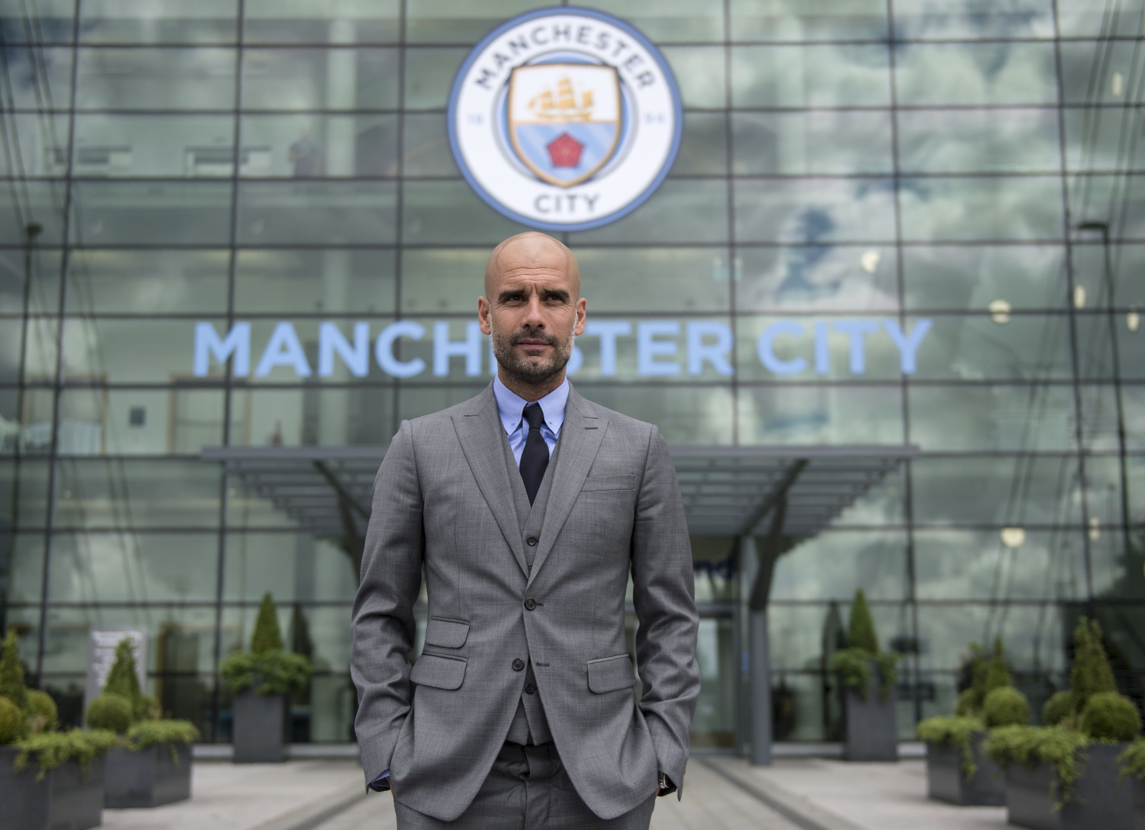 manchester city 039 s spanish football coach pep guardiola poses for pictures outside the etihad stadium in manchester northern england on july 8 2016 pep guardiola has warned his manchester city players that they have to prove themselves all over again following his arrival at the club photo afp