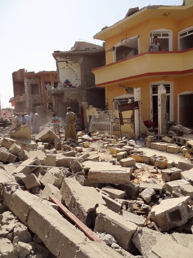 iraqis inspect the remains of houses after a suicide bomber detonated the day before an explosives rigged vehicle on august 11 2013 in the northern city of tuz khurmatu photo afp marwan ibrahim