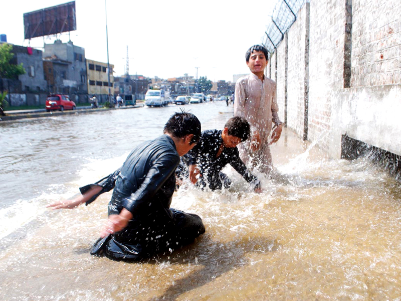 children playing in rainwater to beat the heat on rawal road photo online