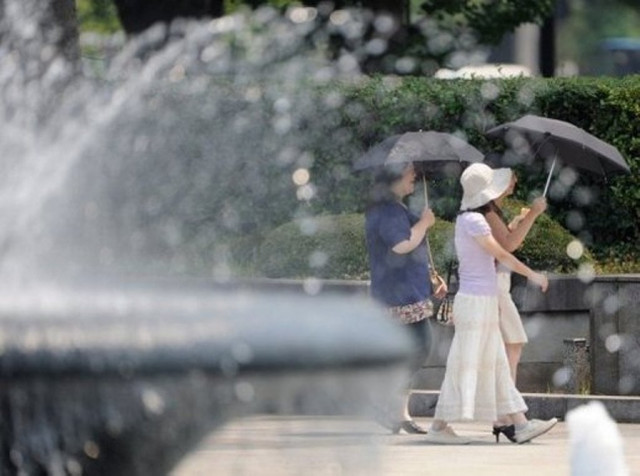 women use umbrellas to shield themselves from the sun in tokyo on july 23 2010 after the heatstroke had resulted in 66 deaths photo afp