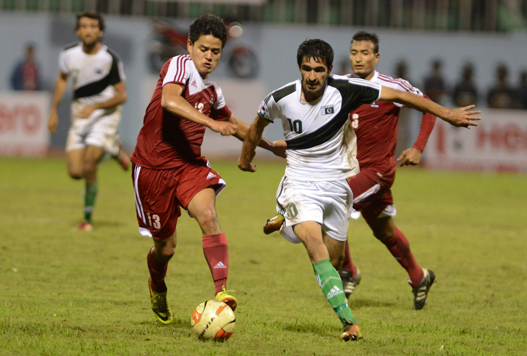 nepalese football player sandip rai l vies for the ball with pakistan opponent kaleemullah during the saff championship football match in kathmandu on september 3 2013 photo afp