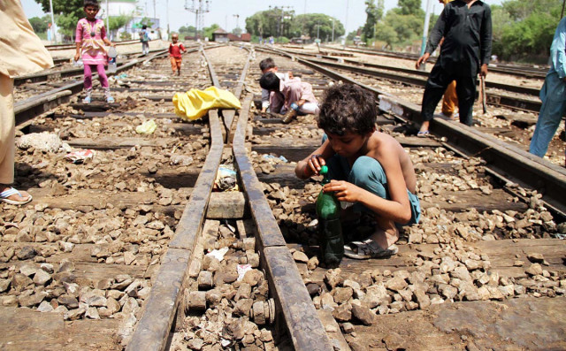 a child fills his bottle with kerosene oil after the oil spill near kotri railway station photo online a child fills his bottle with kerosene oil after the oil spill near kotri railway station photo online