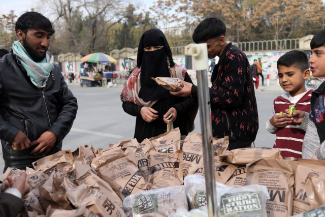 an afghan woman buys food left behind by the us military from a peddler in kabul afghanistan november 17 2021 reuters an afghan woman buys food left behind by the us military from a peddler in kabul afghanistan november 17 2021 reuters