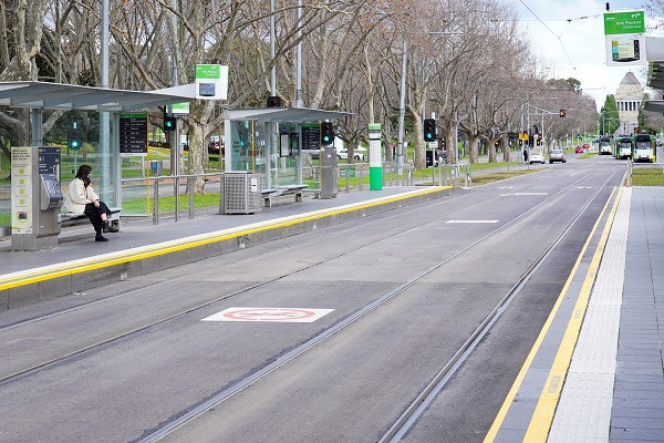a lone passenger sits at a tram stop on a mostly empty city centre street on the first day of a lockdown as the state of victoria looks to curb the spread of a coronavirus disease covid 19 outbreak in melbourne australia photo reuters